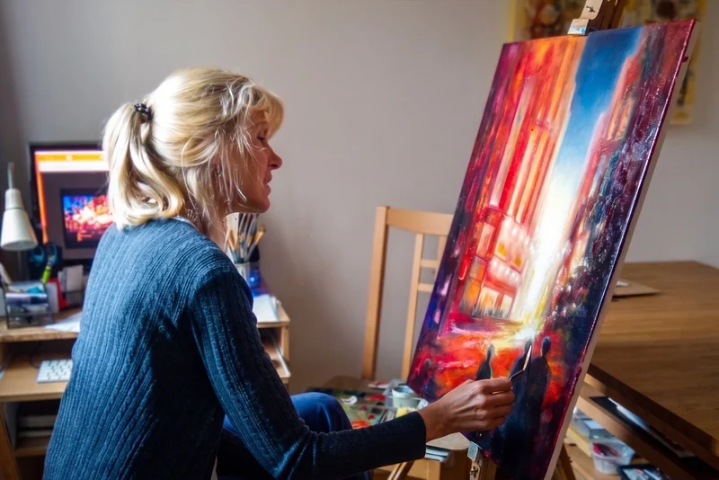 Mila Moroko working on a colourful painting at an easel